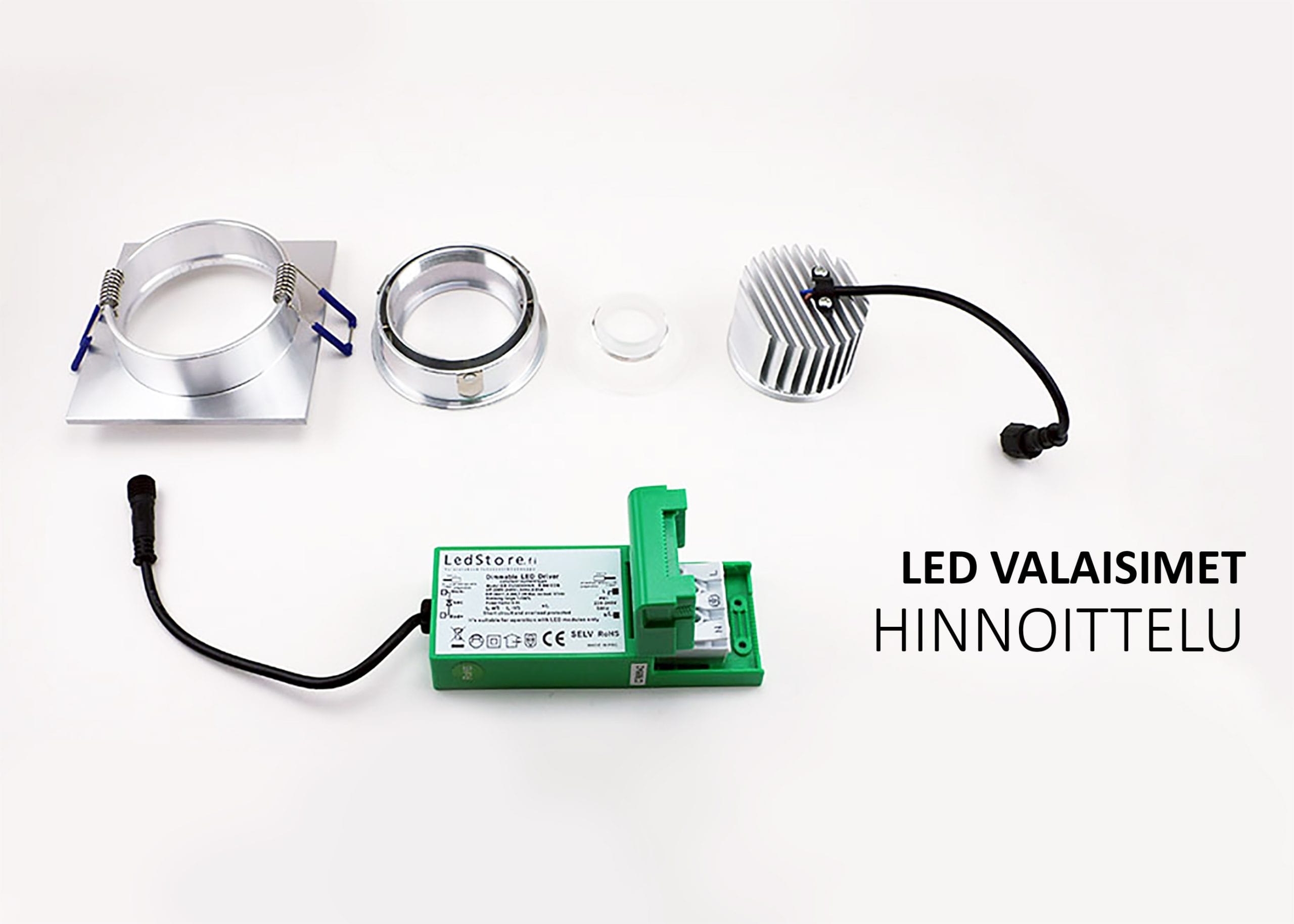 LED-alasvalon komponentit esillä valkoisella taustalla: hopeinen kehys, pyöreä linssi, jäähdytyselementti ja vihreä ohjain johdon kanssa. Texti "LED VALAISIMET HINNOITTELU" suomeksi korostaa LED-teknologian hienostuneita yksityiskohtia.