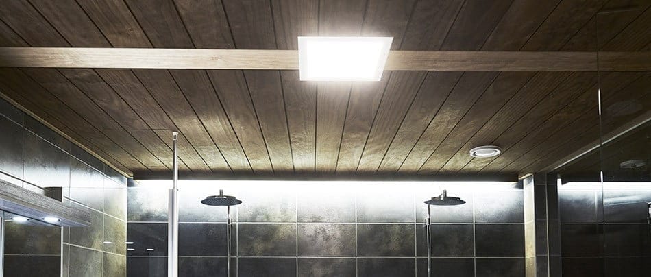Puisella kattopaneelilla varustettu kylpyhuone, jossa på LedStore.fi:n upotetut LED-valaisimet. Tumma laatoitus seinillä ja kaksi sadesuihkua luovat tyylikkään ja modernin tunnelman.